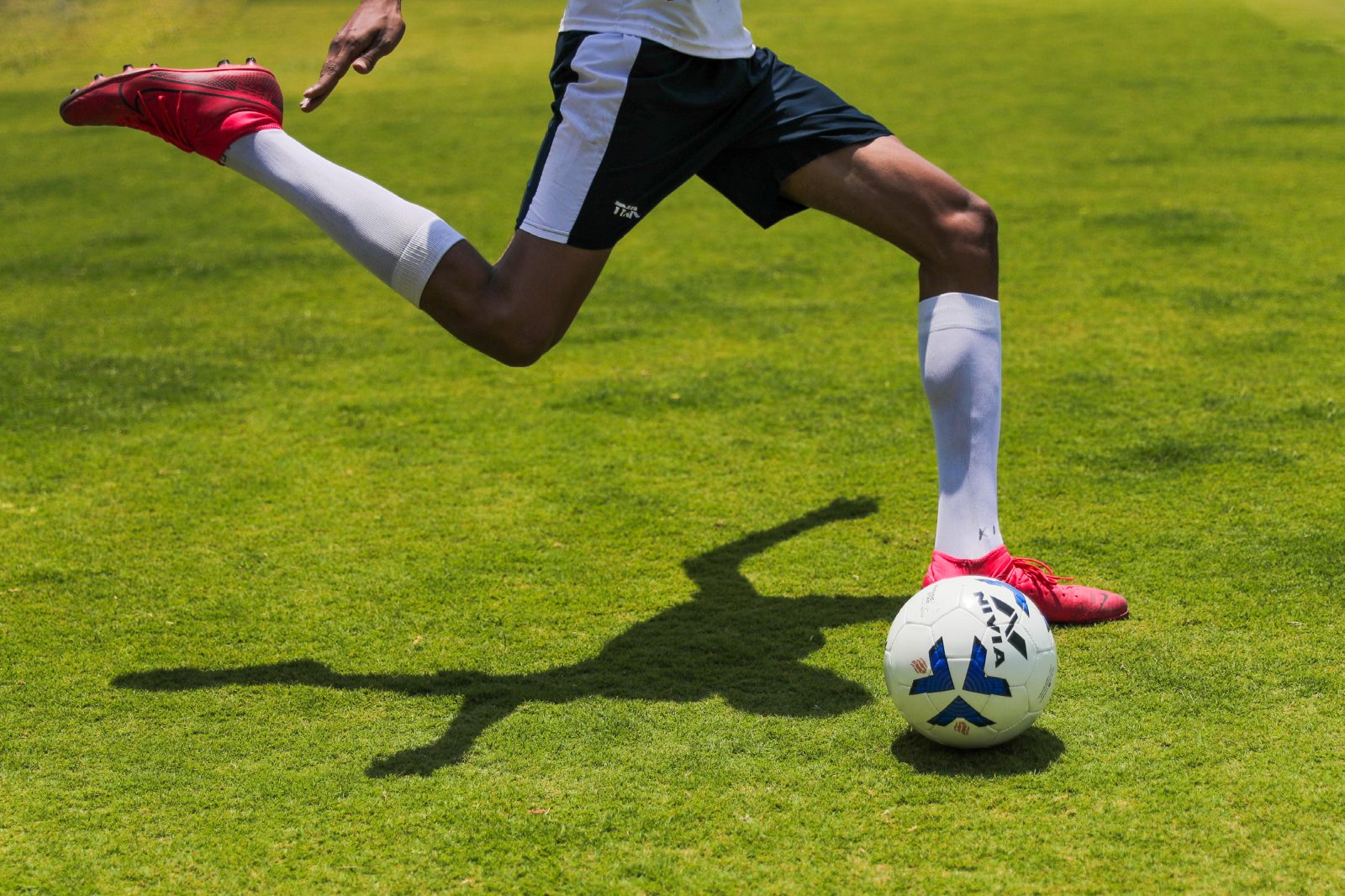 Footballer striking a ball, campaign photography